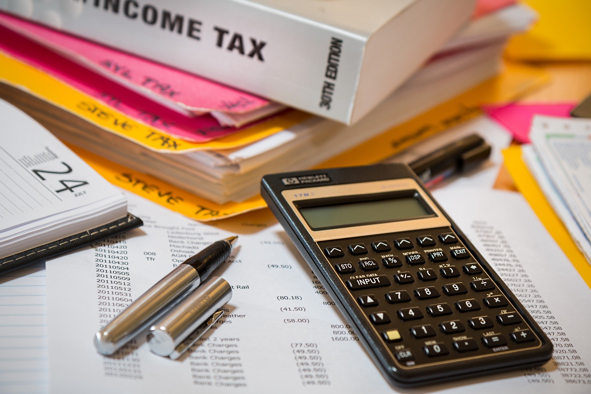 income tax calculator binder pen spreadsheet