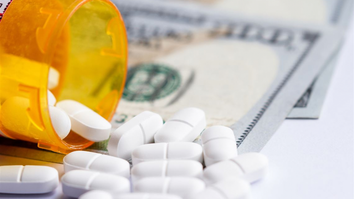 Drug Costs medicine in bottle on money